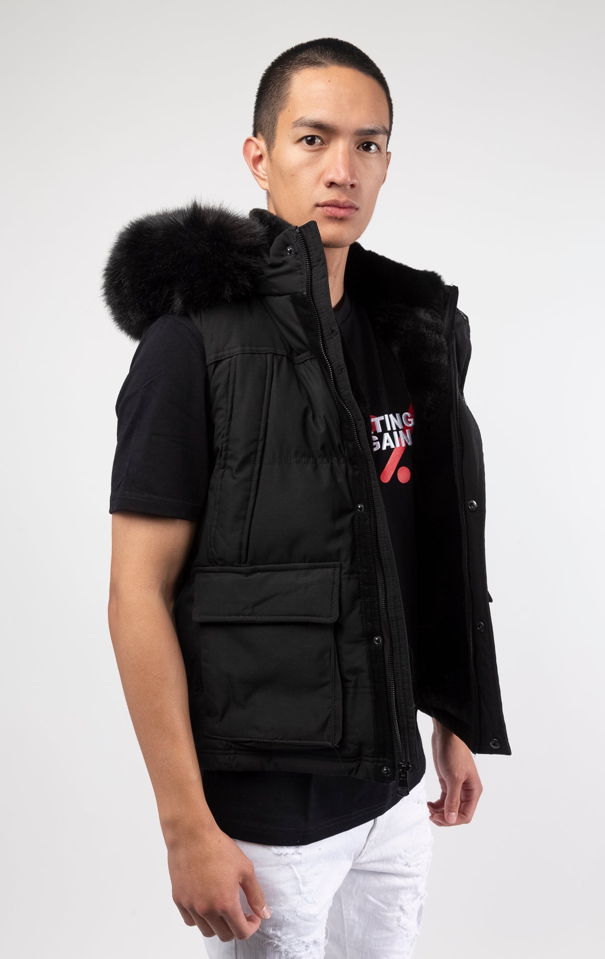 Black Faux fur-lined hooded jacket made of a water-resistant polyester shell featuring a removable hood with a removable faux fox fur trim. The hood and front of the jacket are lined with faux rabbit fur for superior warmth. The jacket has JC branded zippers throughout, dual pockets at the sides with button openings, and a full zipper front opening. Faux suede taping adorns the front zipper.